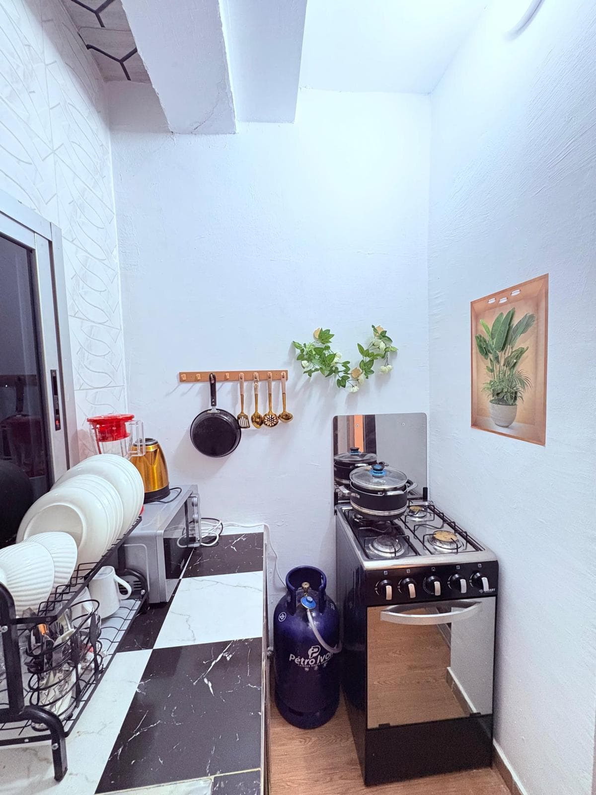 Cuisine équipée avec gazinière, micro-ondes et vaisselle